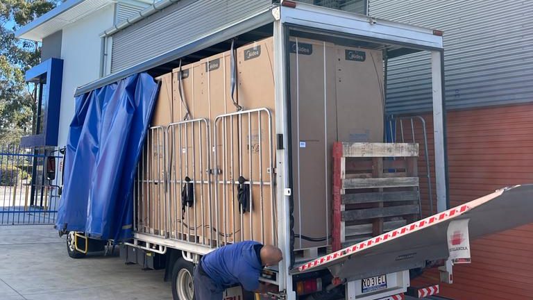 A truck loaded with pallets and securely strapped down, ready for the journey from Sydney to Canberra